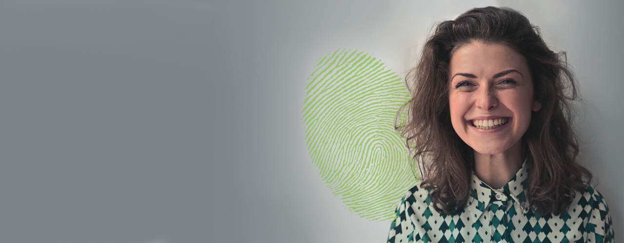 Person smiling with green thumbprint in background